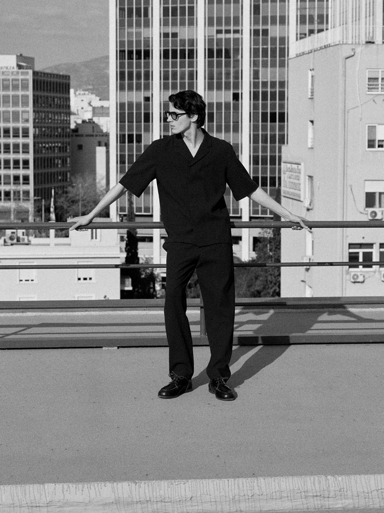 man wearing turtleneck standing on balcony